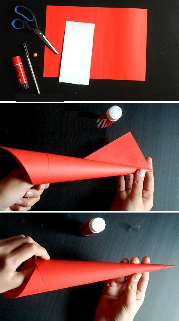 Dùng giấy đỏ cuộn thành hình chóp rồi dùng keo dán cố định lại.