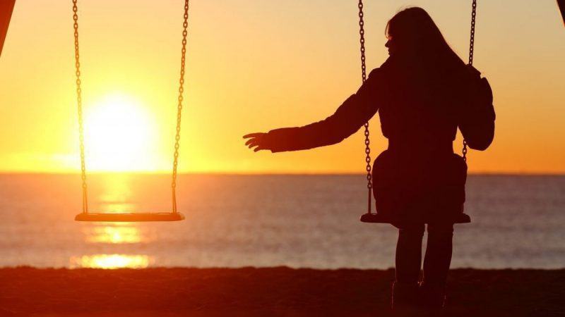 sad image when losing a loved one, a girl sitting on a swing