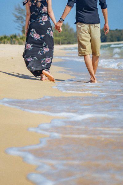 một bức ảnh hai người nắm tay nhau đi dạo trên bãi biển