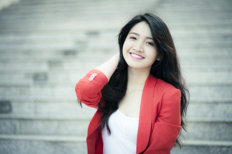 Hình ảnh cô gái mỉm cười mặc vest đỏ